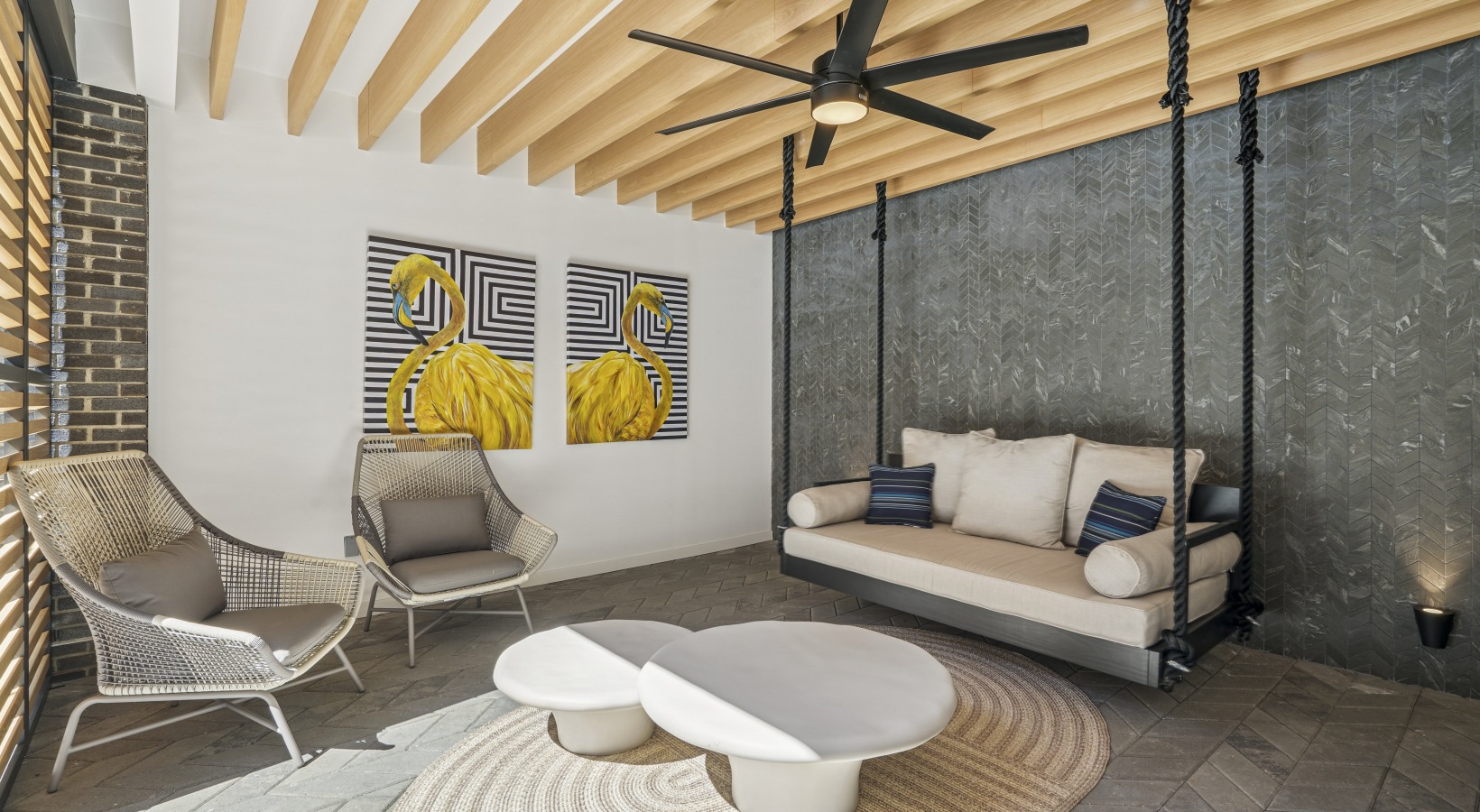 A room with a yellow couch, blue chairs, and a white coffee table.